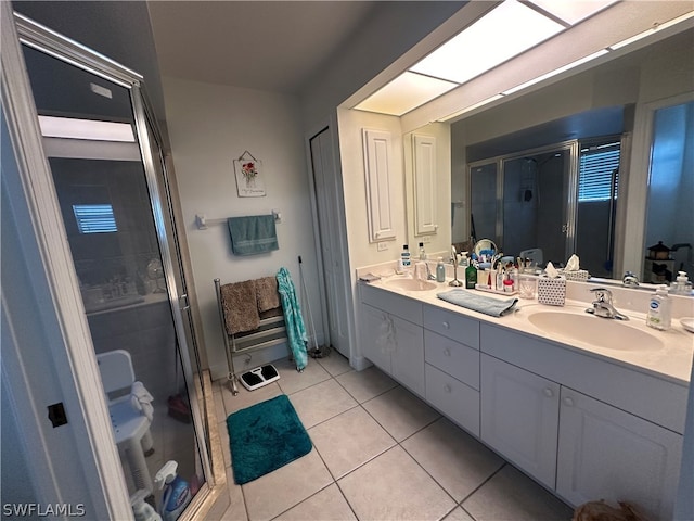 bathroom with walk in shower, double sink, tile floors, and large vanity