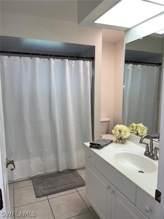 bathroom featuring tile floors, vanity with extensive cabinet space, and toilet