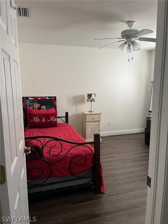 bedroom with dark hardwood / wood-style flooring and ceiling fan