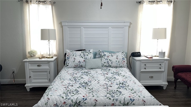 bedroom featuring dark wood-type flooring and multiple windows