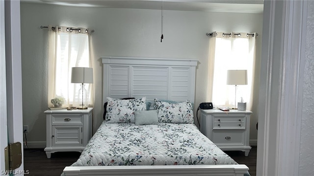 bedroom with dark wood-type flooring and multiple windows