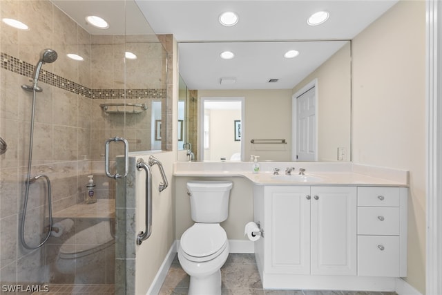 bathroom featuring tile patterned floors, vanity, toilet, and a shower with shower door