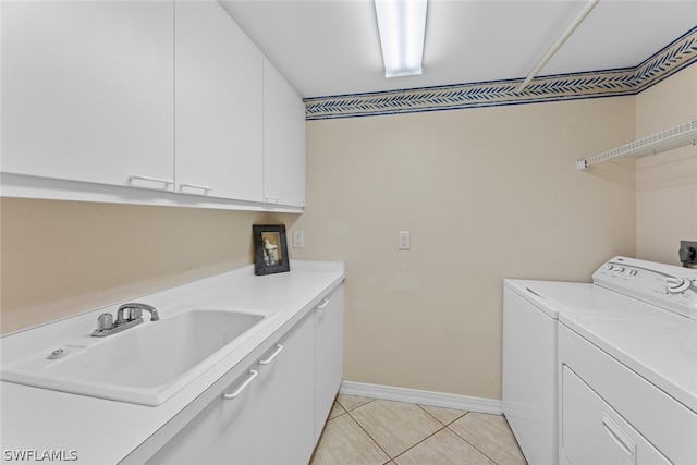 clothes washing area with cabinets, independent washer and dryer, sink, and light tile patterned floors