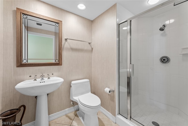 bathroom featuring tile patterned flooring, toilet, a shower with shower door, and sink