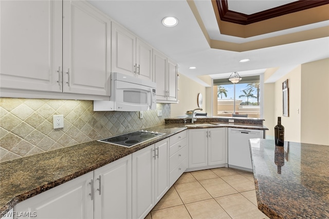 kitchen featuring dark stone countertops, sink, white cabinets, and white appliances