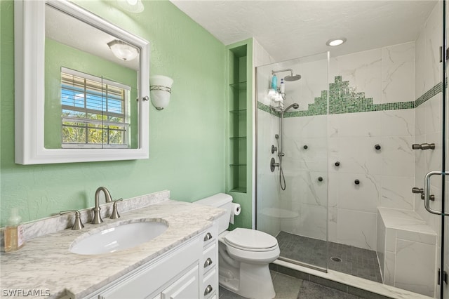 full bath with toilet, a stall shower, a textured wall, and vanity