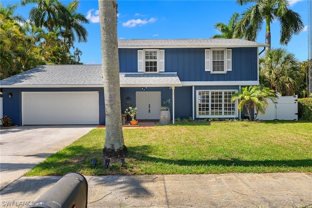 view of front facade featuring a garage, fence, driveway, a front lawn, and board and batten siding