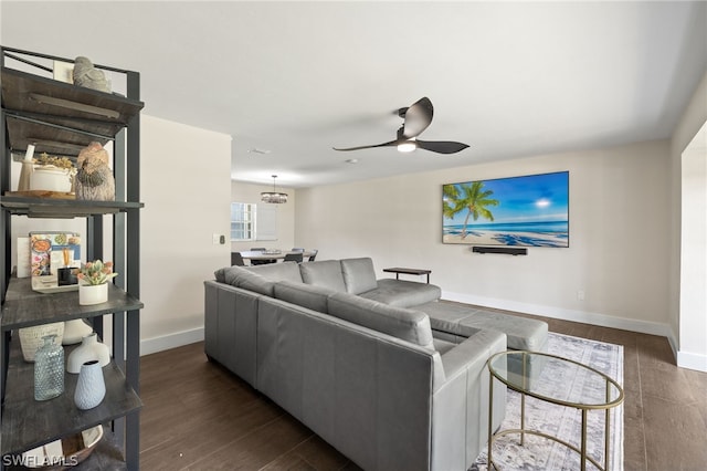 living area featuring a ceiling fan, dark wood-style flooring, and baseboards