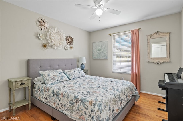 bedroom featuring a ceiling fan, baseboards, and wood finished floors