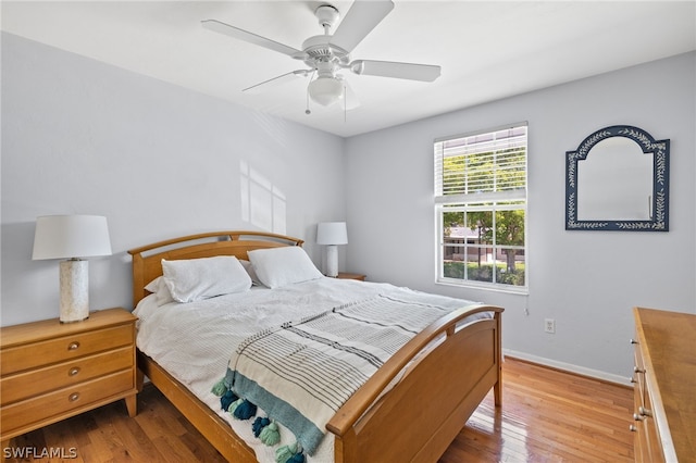 bedroom featuring a ceiling fan, baseboards, and wood finished floors