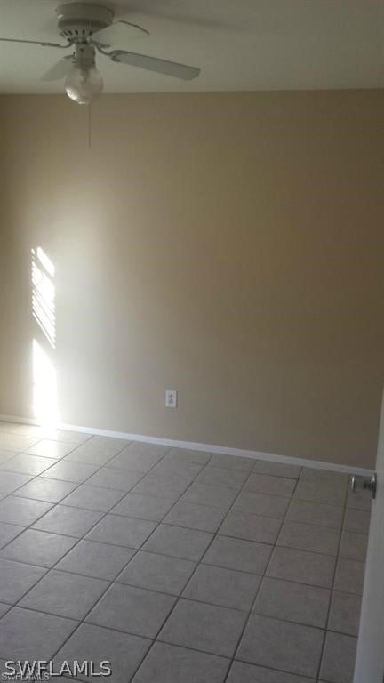 unfurnished room with ceiling fan and light tile patterned flooring