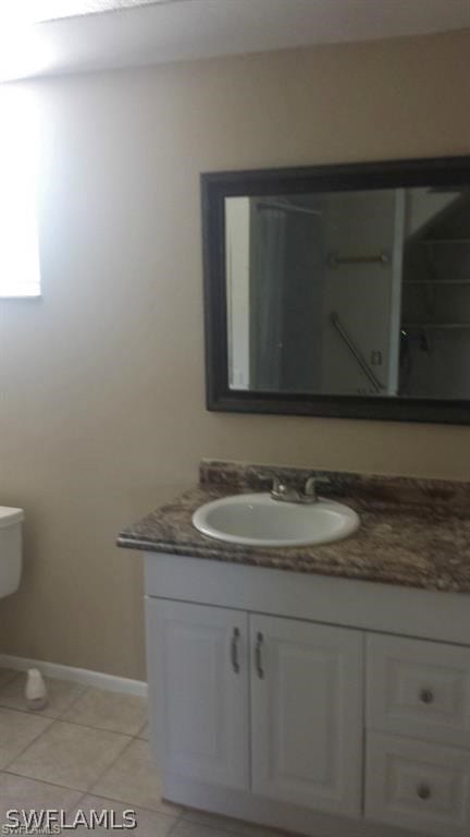 bathroom with tile patterned floors, vanity, and toilet