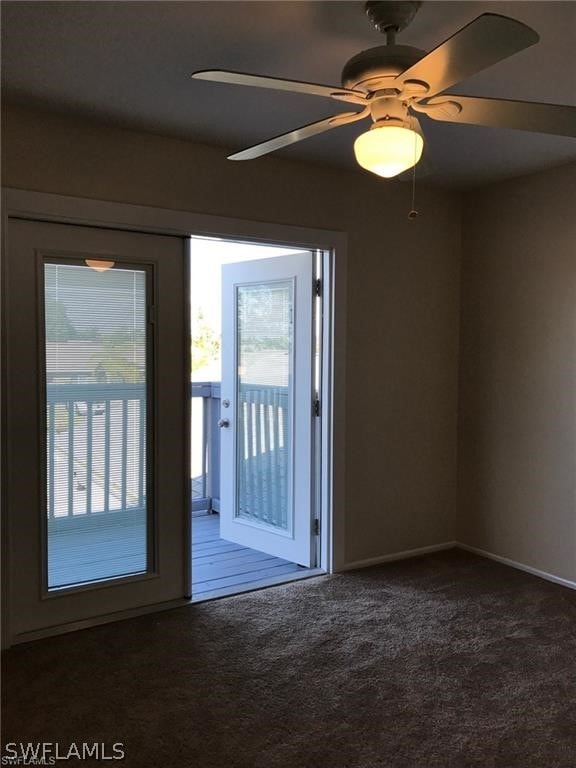 interior space featuring ceiling fan and dark colored carpet