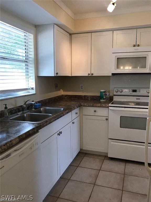 kitchen featuring white cabinetry, white appliances, sink, and light tile patterned floors