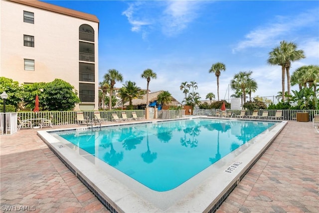 pool with a patio and fence