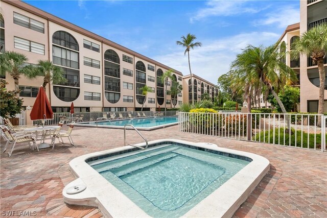 view of swimming pool with a patio area and a hot tub