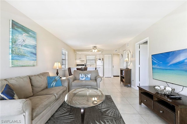 living room featuring light tile patterned flooring, visible vents, and ceiling fan