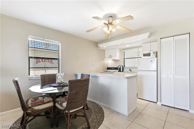kitchen with ceiling fan, light countertops, light tile patterned floors, white appliances, and white cabinetry