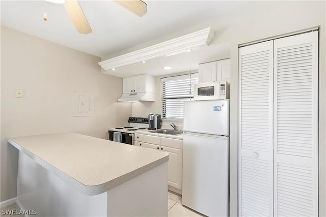 kitchen with a sink, under cabinet range hood, white cabinetry, white appliances, and a peninsula
