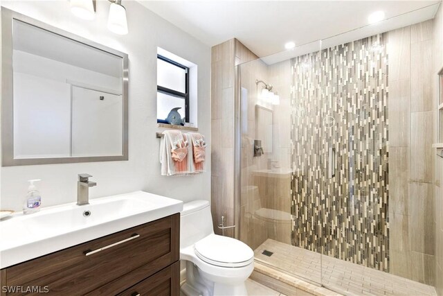 bathroom featuring vanity, an enclosed shower, and toilet