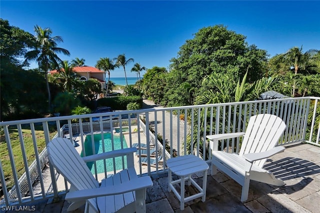 wooden terrace featuring a fenced in pool, a patio, and a water view