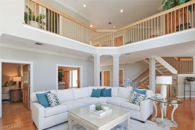 15891 Captiva Dr, Captiva, FL 33924 - living room with stairs, visible vents, decorative columns, and wood finished floors