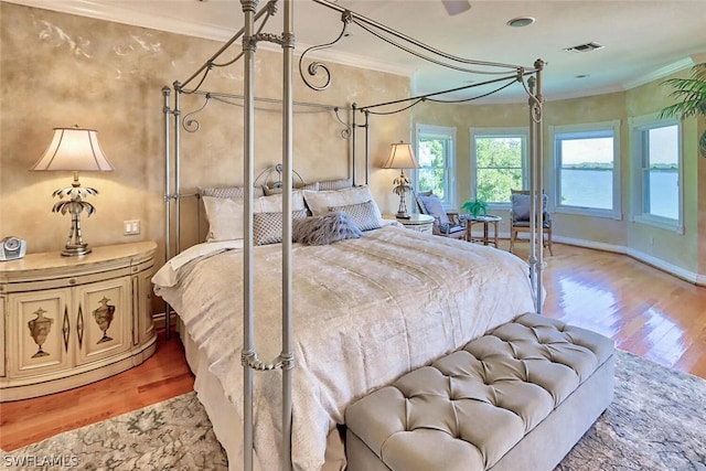 bedroom with wood-type flooring and ornamental molding