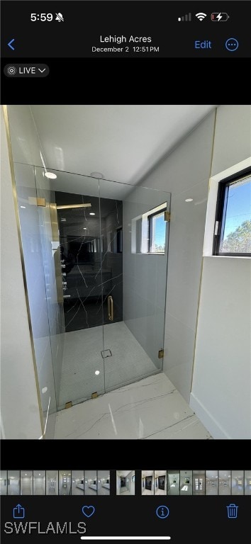 bathroom with a shower with door