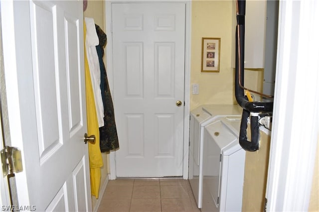 clothes washing area with light tile floors and washing machine and clothes dryer