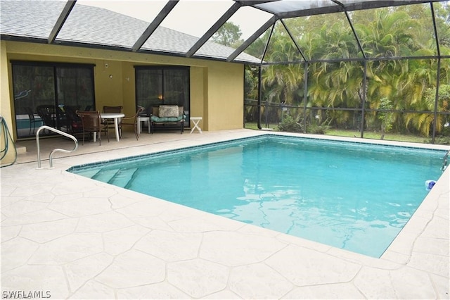 view of swimming pool with glass enclosure and a patio area