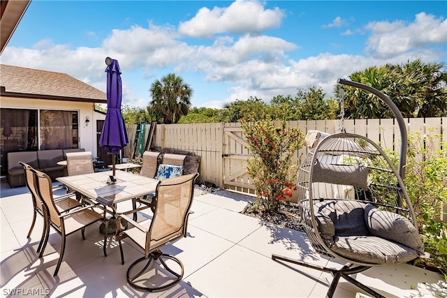 view of patio / terrace with outdoor dining area, fence, and a gate