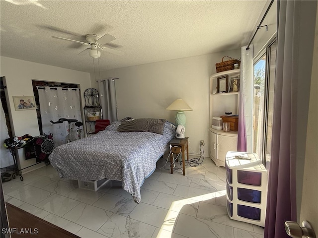 bedroom featuring marble finish floor, a ceiling fan, and a textured ceiling