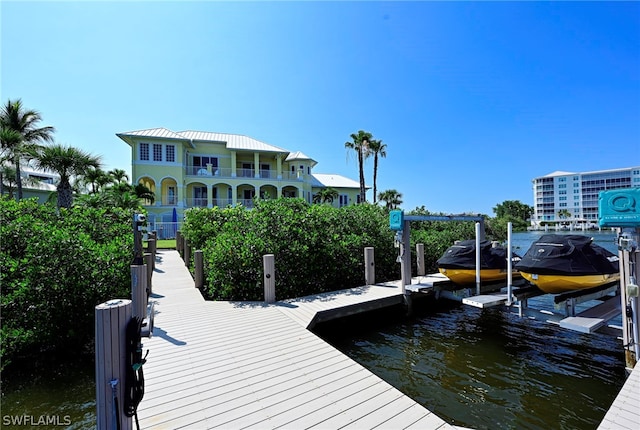 dock area with a water view and a balcony