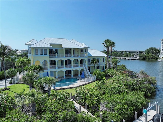 rear view of property with a water view and a balcony