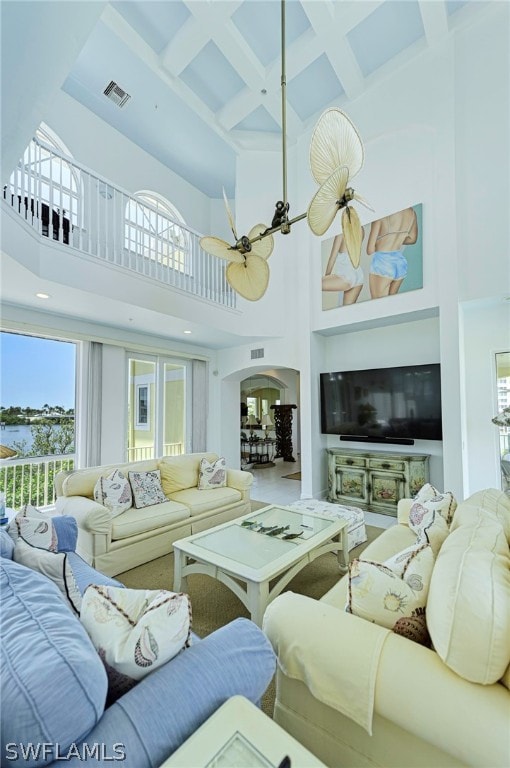 living room featuring beam ceiling, a high ceiling, coffered ceiling, and ceiling fan