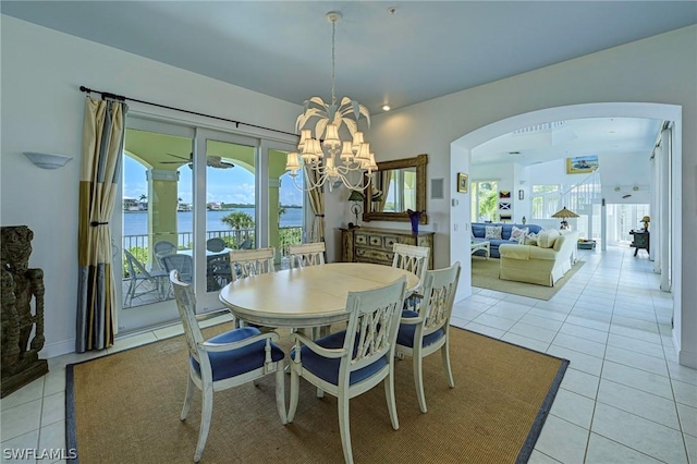 tiled dining area with a water view and a notable chandelier