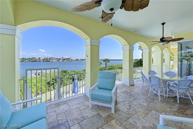 view of patio with ceiling fan and a water view