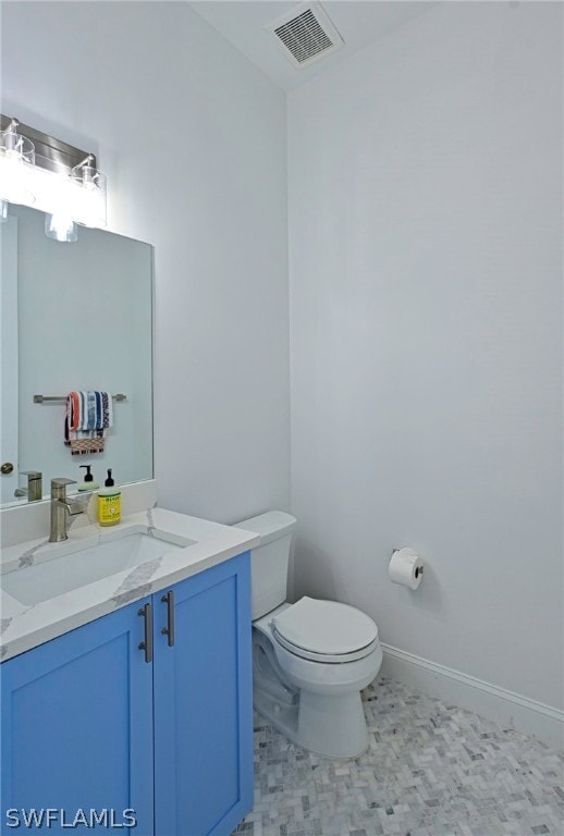 bathroom featuring tile flooring, toilet, and vanity