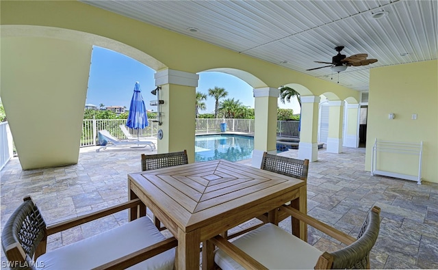 view of patio with ceiling fan and a fenced in pool