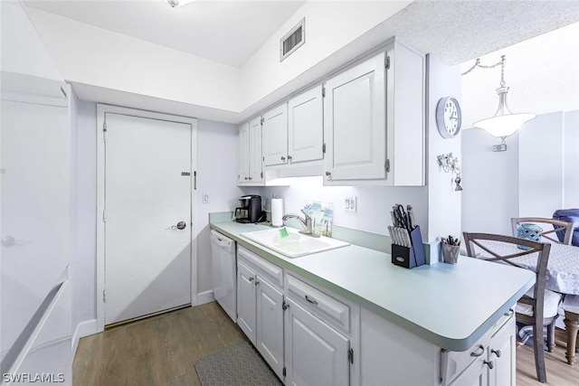 kitchen with kitchen peninsula, hardwood / wood-style floors, white dishwasher, white cabinets, and sink