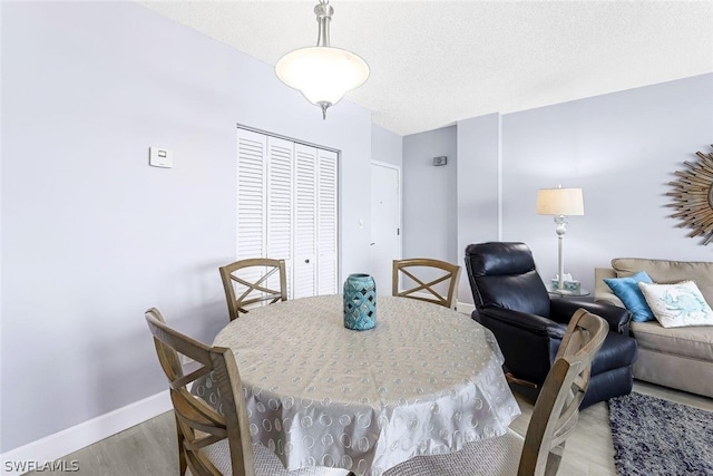 dining area with a textured ceiling and hardwood / wood-style flooring