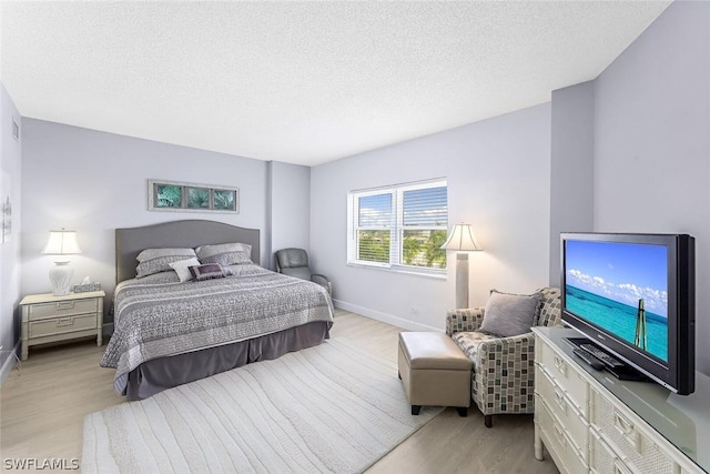 bedroom featuring light hardwood / wood-style flooring and a textured ceiling