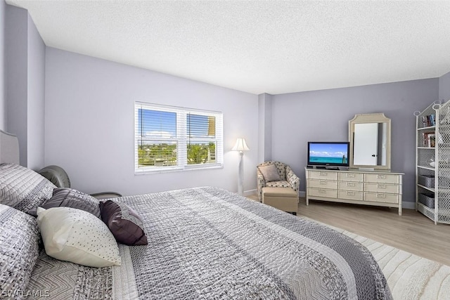 bedroom with hardwood / wood-style flooring and a textured ceiling