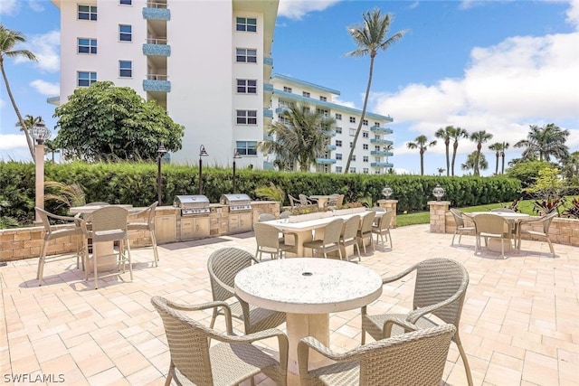 view of patio with a grill, an outdoor kitchen, and a balcony