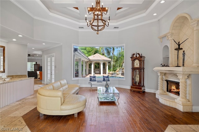 living room featuring beamed ceiling, coffered ceiling, crown molding, and wood-type flooring