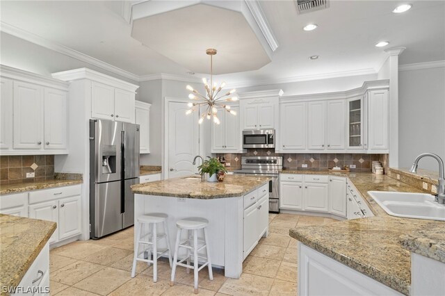 15401 Old Wedgewood Ct, Fort Myers, FL 33908 - kitchen with a kitchen bar, sink, white cabinetry, pendant lighting, and stainless steel appliances