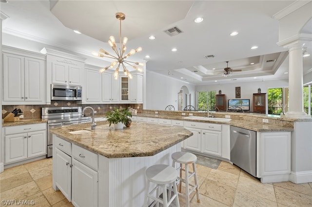 15401 Old Wedgewood Ct, Fort Myers, FL 33908 - kitchen featuring white cabinetry, stainless steel appliances, kitchen peninsula, and a raised ceiling