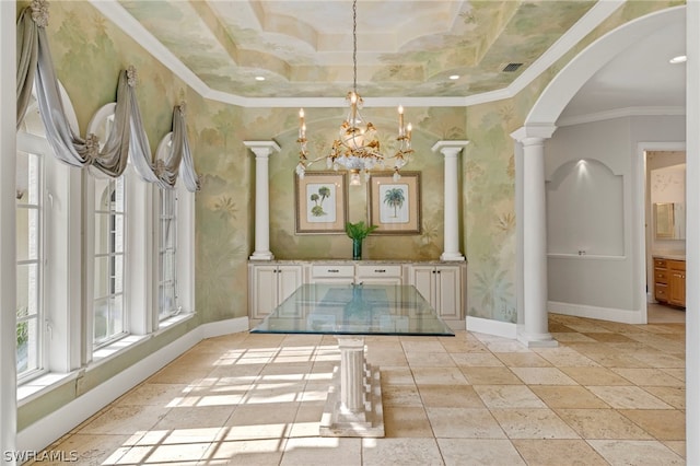 unfurnished dining area featuring a chandelier, light tile flooring, a raised ceiling, crown molding, and decorative columns