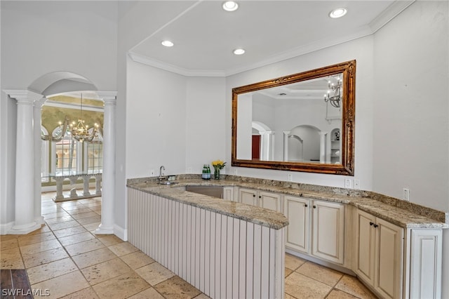 bathroom with a notable chandelier, ornate columns, tile flooring, and crown molding