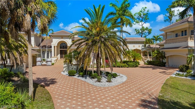 view of front of property with a garage, a balcony, and french doors